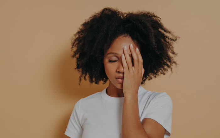 Female covering her face with hand and feeling anxious