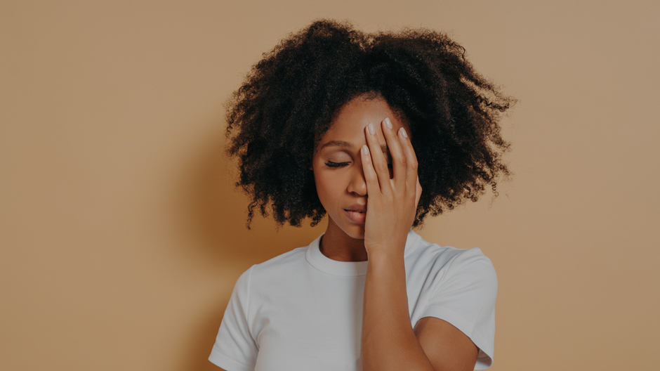 Female covering her face with hand and feeling anxious